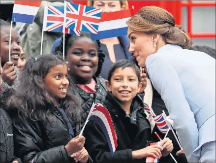  ??  ?? Flag-waving children greet Kate in The Hague yesterday and top, left, the Duchess views the famous painting