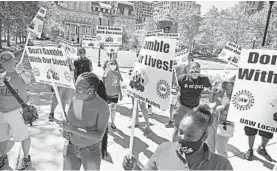  ?? KENNETH K. LAM/BALTIMORE SUN ?? A group of Horseshoe Casino table game dealers and workers staged a rally at City Hall to demand city government require safer work environmen­t for workers.