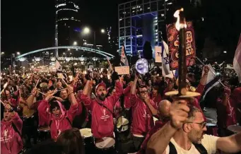  ?? Oded Balilty/Associated Press ?? Israelis carry torches at a protest in Tel Aviv against Israeli Prime Minister Benjamin Netanyahu and his far-right government that his opponents say threatens democracy and freedoms.