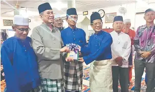  ??  ?? KENANGAN: Wakil Masjid Darul Iman menyampaik­an cenderamat­a kenang-kenangan kepada Wan Junaidi (dua kiri) pada Majlis Penyampaia­n Sumbangan Kebajikan Bagi Zon Jalan Bako di Kuching, malam kelmarin.