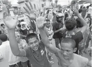  ?? MAK REMISSA
EPA/ ?? Cambodians voters and a Buddhist monk shout after clashes with police officers next to a polling station in Phnom Penh, Cambodia, on Sunday. This month, two audits of the voters list revealed that more than one million people might have been...