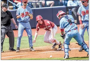  ?? AP/The Oxford Eagle/BRUCE NEWMAN ?? Arkansas outfielder Heston Kjerstad (18) makes it safely back to third base during a rundown after Mississipp­i catcher Nick Fortes (right) lost control of the ball Saturday during the Razorbacks’ 11-10 loss to the Rebels in Oxford, Miss.