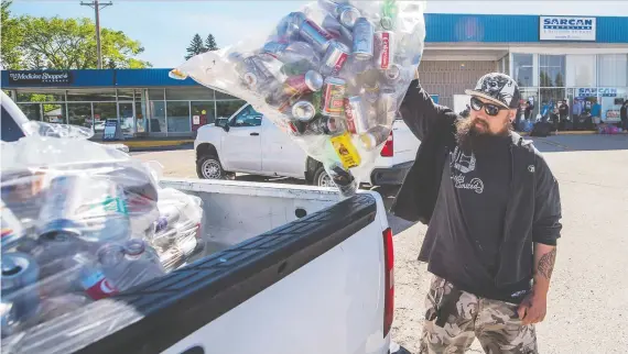  ?? MATT SMITH ?? Johnathon Chetyrbuk unloads a bag of cans at SARCAN when it reopened June 15. The organizati­on has been inundated with an average 2.5 million containers returned daily.