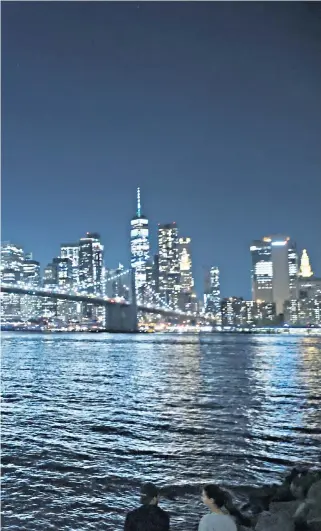  ??  ?? New Yorkers take in their city’s illuminate­d skyline ahead of today’s anniversar­y