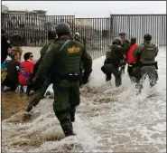  ??  ?? Border Patrol agents (right) detain a man during a protest in San Diego near the border with Tijuana, Mexico, in 2018. (AP/Gregory Bull)