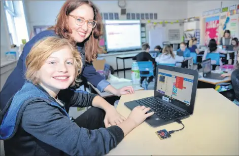  ?? TERRENCE MCEACHERN/THE GUARDIAN ?? Carron McCabe, program director with Brilliant Labs, discusses coding with student Kai Gillan-Johnson during the Hour of Code event held at West Kent Elementary Wednesday. Students were encouraged to build their coding skills as part of the global event.