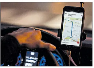  ?? Bloomberg/ANDREW HARRER ?? A driver uses an Uber Technologi­es Inc. car-service app in Washington, D.C., in November.