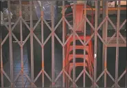  ??  ?? Dining chairs are seen stacked at a restaurant temporaril­y closed.