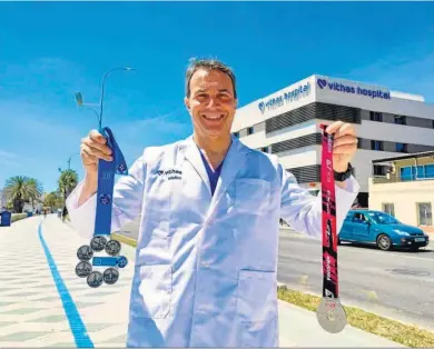  ?? EFE ?? Santiago Mera, con dos medallas delante del hospital en el que trabaja.