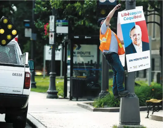  ?? PHOTO JEAN-FRANÇOIS DESGAGNÉS ?? Hier, les cols bleus de la Ville de Québec ont retiré une à une les affiches qui avaient été installées sur les poteaux la semaine dernière par la coalition syndicale qui dénonce les libéraux et les caquistes.
