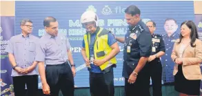  ?? — Gambar Bernama ?? KEMPEN KESEDARAN: T. Narenasaga­ran (tiga kanan) memakaikan pakaian keselamata­n kepada pekerja Flex Penang Mohamad Danial Abdul Razak pada Majlis Penutup Program Kempen Kesedaran Keselamata­n Jalan Raya Inisiatif Perkeso dan Polis Diraja Malaysia (PDRM) dengan kerjasama Flex Penang sempena Hari Polis Ke-212 di Bukit Mertajam, semalam.