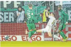  ?? FOTO: ANSPACH/DPA ?? Mönchengla­dbachs Robin Hack (links) bringt die Borussia mit 1:0 in Führung, die Grätsche von Marcel Gaus kommt zu spät.