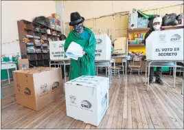  ?? Dolores Ochoa The Associated Press ?? A voter carries her ballots during general elections in Cangahua, Ecuador, on Sunday. Amid the new coronaviru­s pandemic, Ecuadorean­s went to the polls in a first-round of presidenti­al and legislativ­e elections.