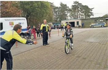  ?? RP-FOTO: NICOLE PETERS ?? Die Verkehrssi­cherheitsb­erater Jürgen Soyka (links) und Jörg Zimmermann-Ramöller (rechts) gaben den jungen Verkehrste­ilnehmern auf dem Gelände der ZUE Petersholz wertvolle Tipps.