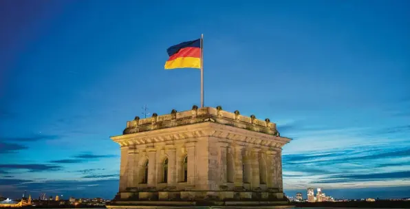  ?? Foto: Kay Nietfeld, dpa ?? Immerhin: Schwarz-Rot-Gold weht über dem deutschen Reichstag in Berlin. Doch im Gebäude selber wird der Alltag von der Corona-Krise bestimmt.