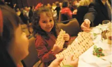  ?? Lea Suzuki / The Chronicle 2006 ?? Emma Marino (left) and Sophie Levine break the matzo during a Passover seder at the S.F. Jewish Community Center.