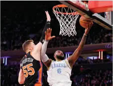  ?? AFP photo — ?? James (right) heads for the net as Isaiah Hartenstei­n of the New York Knicks defends in the second half at Madison Square Garden in New York City.