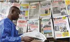  ??  ?? BAMAKO: A man reads a newspaper near a newsstand yesterday, three days after a deadly attack at the Radisson Blu hotel. — AFP