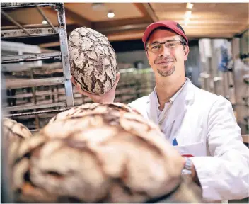  ?? RP-FOTO: RALPH MATZERATH ?? Rund, riesig, nahrhaft: Markus Soerries, Backstuben-Leiter bei Busch, mit einem Klassiker aus dem Sortiment der Monheimer Bäckerei.