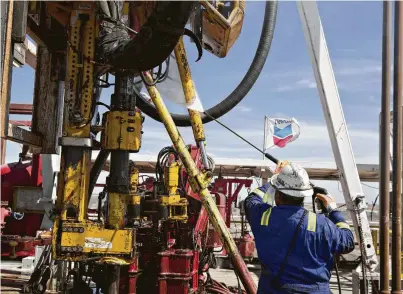  ?? Daniel Acker / Bloomberg file ?? A roughneck cleans the drilling floor of a rig working for Chevron in the Permian Basin near Midland. A report by IHS Markit says the supermajor­s working in the Permian will need to invest heavily to reach production targets.