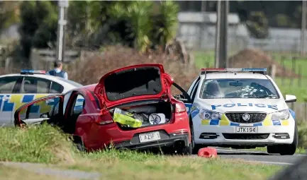  ?? PHOTO: CHRISTEL YARDLEY/STUFF ?? The red Holden was abandoned before a shootout in Morrinsvil­le. Bullet holes can be seen in the front windscreen of a police car.