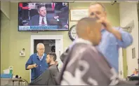  ?? AP PHOTO ?? Barbers cut hair for customers as televised coverage of former FBI director James Comey testifying is seen on television screen at Puglisi Hair Cuts in the Foggy Bottom neighborho­od of Washington, D.C. Thursday.