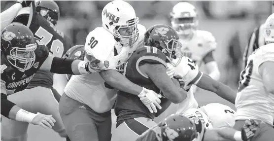  ?? | NIU ATHLETICS ?? Defensive tackle William Lee tries to bring down Central Michigan running back Jahray Hayes. The skidding Huskies stumbled on the road in theirMAC opener.