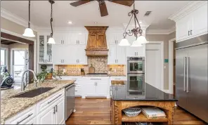  ?? ?? Highlights of the kitchen include granite countertop­s, an abundance of cabinets, two islands and a breakfast bar.