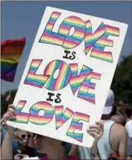  ?? THE ASSOCIATED PRESS ?? A marcher hold a sign that reads “Love is Love is Love” on the National Mall with the Washington Monument in the background during the Equality March for Unity and Pride in Washington, Sunday, June 11, 2017.