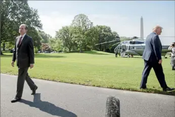 ?? Andrew Harnik/ Associated Press ?? Labor Secretary Alexander Acosta walks back into the White House as President Donald Trump speaks to members of the media Friday on the South Lawn in Washington before boarding Marine One. Mr. Acosta announced his resignatio­n Friday.