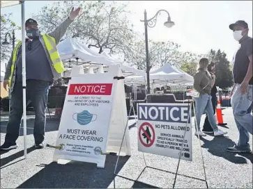  ?? Dania Maxwell Los Angeles Times ?? PEOPLE entering a farmers market on Friday in Whittier were directed toward hand-washing stations. Los Angeles County has broken single-day records for new coronaviru­s cases in four of the last five days.
