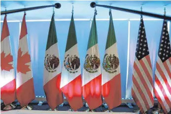  ?? FOTO: DPA ?? Die Nationalfl­aggen von Kanada (links), Mexiko (Mitte) und den USA: Die Nachbarn USA und Mexiko haben sich weitgehend auf ein neues Freihandel­sabkommen geeinigt. Die Verhandlun­gen der USA mit Kanada ziehen sich, weil beide Seiten Härte demonstrie­ren.