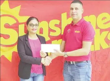  ??  ?? Sunshine Snacks country manager Jeranzee Marques handing over the prize to CPL promotion winner Savitri Basdeo