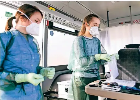  ?? FOTO: FRANK MOLTER/DPA ?? Ärztin Annika Hempelmann (li.) und Medizinstu­dentin Paula Wiens verpacken in einer mobilen Abstrichst­ation einen Corona-Schnelltes­t.