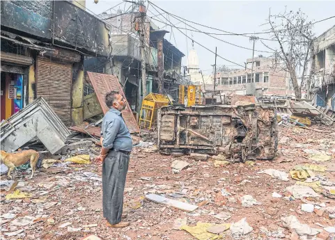 ?? AFP ?? A resident looks at burnt-out and damaged homes and shops following clashes between people supporting and opposing a contentiou­s amendment to India’s citizenshi­p law, in New Delhi yesterday.