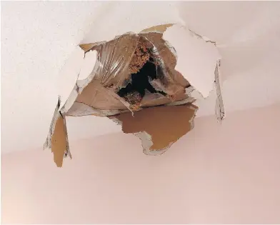  ?? PHOTOS: LEAH HENNEL / POSTMEDIA ?? The hole in the ceiling of Theresa and Richard Couch’s roof in Calgary caused by falling ice from a Q400 aircraft.