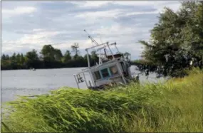  ?? GERALD HERBERT — THE ASSOCIATED PRESS ?? Grass blows in the breeze in front of a boat that sunk from last year’s Hurricane Nate, in advance of Tropical Storm Gordon, expected to make landfall as a hurricane this evening, in Pass Christian, Miss., Tuesday, Sept. 4, 2018.