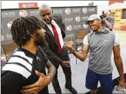  ?? CURTIS COMPTON/CCOMPTON@AJC.COM ?? Hawks players DeAndre’ Bembry (left) and Kent Bazemore welcome new coach Lloyd Pierce to town Monday in Atlanta.