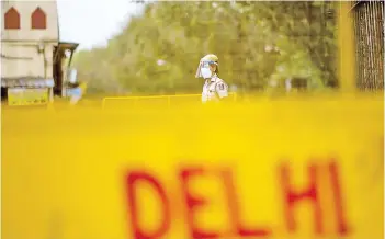 ?? — AFP photo ?? A policewoma­n stands guard at a roadblock in New Delhi, as India locked down its capital for a week beginning April 19 seeking to control a raging coronaviru­s outbreak.