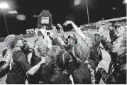  ?? [PHOTO BY BRYAN TERRY, THE OKLAHOMAN] ?? Westmoore players raise the Class 6A state championsh­ip trophy after beating Edmond North on Wednesday night in Shawnee.