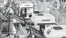  ?? XU CHANG / XINHUA ?? Industrial robots assemble and paint trucks at a factory of China FAW Group in Changchun, Jilin province.