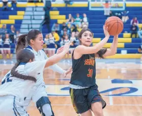  ?? EDDIE MOORE/JOURNAL ?? Española Valley’s Kaylee Chavez, right, drives to the basket while guarded by Santa Fe High’s Kabreya Garcia, left, and Taylor Sanchez at a game Wednesday in Santa Fe. The Sundevils won 64-50.