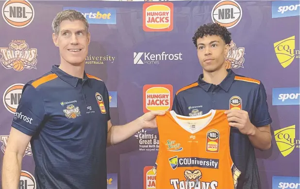  ?? Picture: JORDAN GERRANS ?? KEEN: Coach Mike Kelly presents the newest Cairns Taipans recruit Mojave King with his singlet yesterday morning.