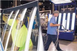  ?? TY WRIGHT/BLOOMBERG ?? An employee lifts a piece of auto glass after cleaning it at the Fuyao Glass America production facility in Moraine, Ohio, in 2016.