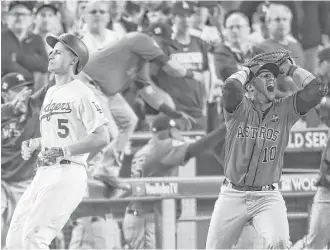  ?? Michael Ciaglo / Houston Chronicle ?? Astros first baseman Yuli Gurriel, right, is in disbelief after catching the final out in the ninth inning to make the Astros World Series champions Wednesday night.