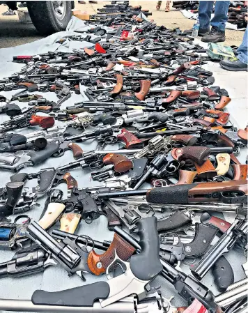  ??  ?? The haul of more than 1,000 guns and, top left, thousands of rounds of ammunition discovered at a $7 million mansion in Los Angeles