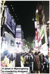  ??  ?? A street in Myeongdong is crowded by shoppers.