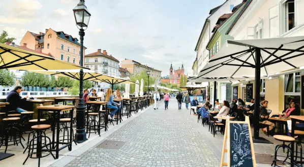  ?? ?? Ljubljana’s riverfront promenade is lined with quaint boutiques, great restaurant­s and cafés. CAMERON HEWITT