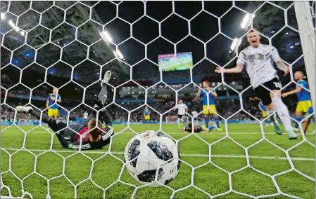  ?? THANASSIS STAVRAKIS/AP PHOTO ?? Germany’s Marco Reus follows the ball into the net after scoring the tying goal during Saturday’s World Cup Group F match against Sweden in Sochi, Russa. The defending champions, on the verge of being eliminated, rallied for a dramatic 2-1 victory with two second-half goals.