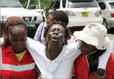  ?? THE ASSOCIATED PRESS ?? Red Cross staff console a woman after she viewed the body of a relative killed in Thursday’s attack on a university, at Chiromo funeral home in Nairobi, Kenya, on Sunday.